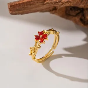 Close-up of a gold plum blossom ring with red crystals and branch-like band