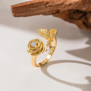 Macro detail of gold rose and butterfly open ring with sparkling micro-set zircons