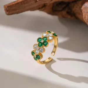 Detailed view of micro-paved green and white zircon flowers on a gold open ring