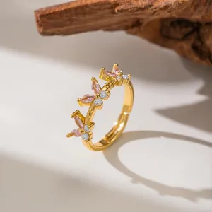 Macro view of a gold-plated open ring featuring delicate pink zircon butterflies