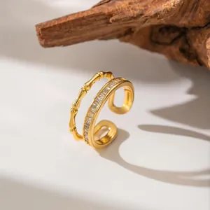 Detail of gold double-layer open ring with baguette-cut zircon and bamboo texture.