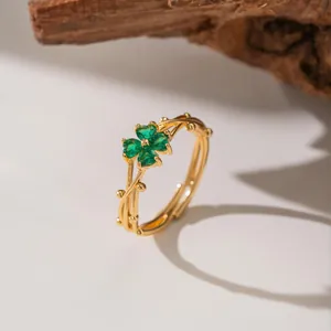 Macro view of gold ring with green four-leaf clover stones on a twig-like band