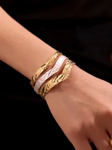 Dettaglio dei bracciali multistrato in acciaio inossidabile placcati in oro 18k