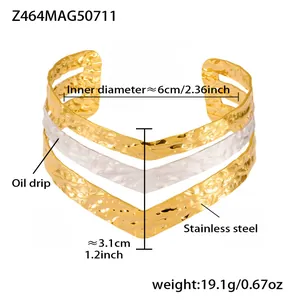Macro detail of triple-layer wavy gold and white oil drip cuff bracelet in stainless steel