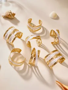 Detail of 18k gold plated multi-layer layered cuff bracelets with shell and palm shadows