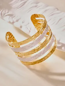 Macro shot of gold and silver multi-layer cuff bracelet with elegant hammered texture