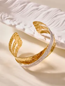 Dettaglio del bracciale rigido multistrato con texture martellata oro e argento placcato 18k