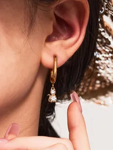 Detailed view of 18k gold plated cat hoop earrings with crystal studs on female model