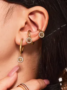 Vue macro de boucles d'oreilles et bague arbre de vie dorés avec incrustations de zircon