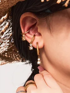 Detail of 18k gold plated cat earrings and cubic zirconia ear cuffs on a model