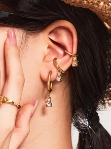 Detailed view of 18k gold plated cat-ear hoop earrings and ear cuffs on a model
