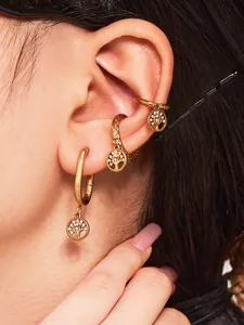 Vue macro des boucles d'oreilles Arbre de Vie dorées avec zircons et bagues d'oreilles