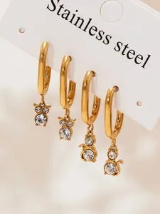 Detail of 18k gold plated stainless steel hoop earrings with cat and owl zircon charms