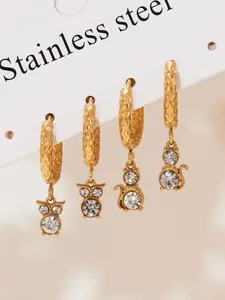 Detail view of four stainless steel gold cat and owl earrings with shiny crystals