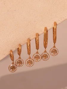 Détail d'un lot de six boucles d'oreilles dorées arbre de vie avec zircons brillants