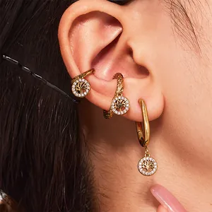 Boucles d'oreilles Arbre de Vie dorées avec oxydes de zirconium portées par un mannequin