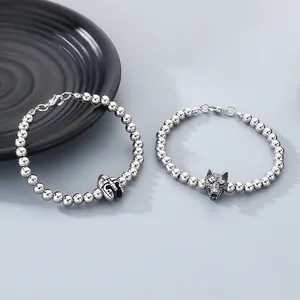 Detail view of 6mm stainless steel bead bracelets with wolf head and helmet charms