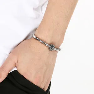 Detailed shot of a stainless steel skull bead bracelet for men and women worn on a wrist
