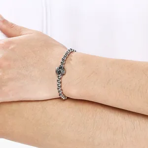 Detail shot of 6mm stainless steel bead bracelet with a central skull charm on wrist