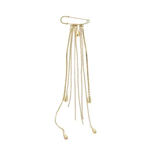 Gold-toned safety pin brooch with multi-layered chain tassels and teardrop pendants