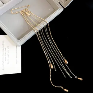 Detailed view of luxury gold-toned metal long chain tassel brooch with elegant water-drop pendants