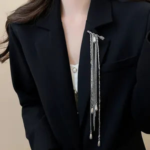 Detail showing a stylish silver long tassel chain brooch with teardrops on a black blazer