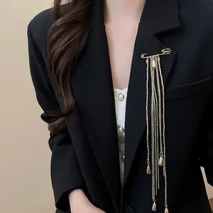 Detailed shot of a luxury gold chain tassel brooch pinned on a black blazer lapel