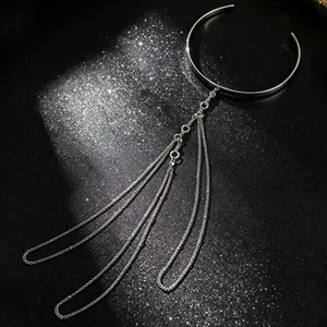 Detailopname van zilveren meerlaagse kwastjesketting armmanchet op een glimmende achtergrond.