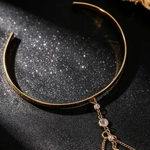 Detail van gouden armmanchet met kristallen hangers op een glitter achtergrond