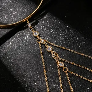 Macro detail van gouden meerlaagse kwastjesarmketting met fonkelende kristalstenen