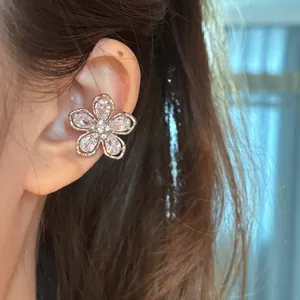 Gros plan d'un ear cuff fleur en zircone étincelant porté sur le cartilage