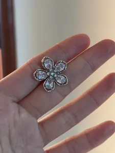 Vue détaillée d'un ear cuff fleur en argent avec des oxydes de zirconium brillants.
