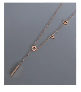 Detail of rose gold Y-shaped necklace with LOVE letter pendant and minimalist bar