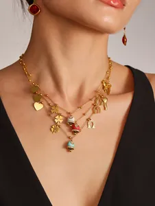 Close-up of layered gold necklaces featuring colorful enamel bells and lucky clover charms