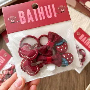 Dettaglio di elastici per capelli a fiocco rosso per bambine con fragole e mele