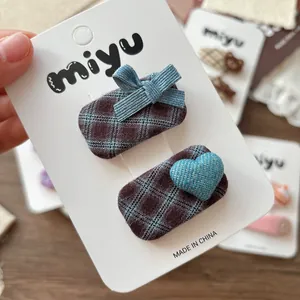 Lot de barrettes à cheveux à carreaux et cœur en denim sur carte avec fond en dentelle