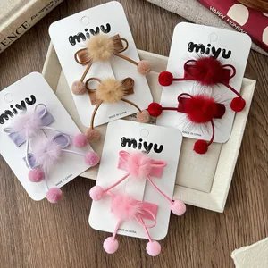 Détail des barrettes à nœuds en peluche aux couleurs d'automne sur carte de marque