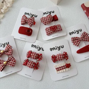 Detail van rood-wit geruite strik haarspeldjes set op een stijlvolle presentatiekaart