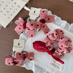 Set accessori per capelli rosa a pois con elastico a fiocco e clip su tavolo vintage