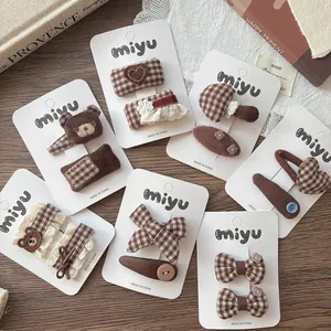 Detail of brown plaid bow hair clips and bear hairpins for girls on a vintage background