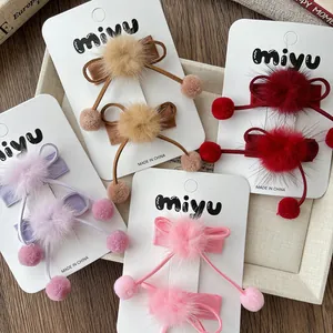 Vue détaillée de pinces à cheveux avec nœuds en velours et pompons en couleurs
