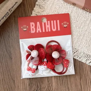 Dettaglio di elastici per capelli a fiore in velluto rosso con ciondoli a forma di coniglio