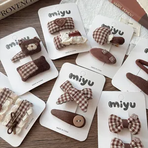 Close-up of assorted fabric bow hair clips with plaid and corduroy textures for girls