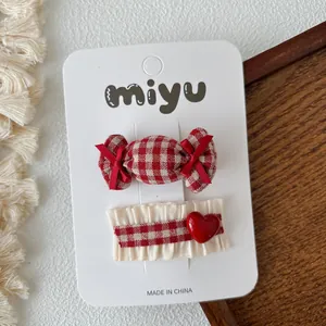 Detail van rood en wit geruite strik haarclips set met hartjes en snoepjes voor meisjes
