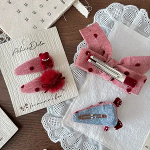 Dettaglio del fiocco in velluto a pois rosa e fermaglio a orsetto su legno
