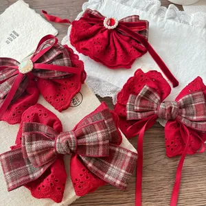 Detail of red lace bow hair clips with pearls and plaid patterns on vintage background