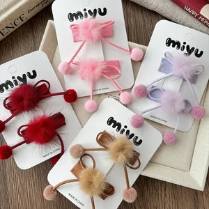 Vue détaillée de barrettes nœuds en peluche avec pompons doux pour petites filles