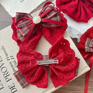 Elegant large red lace bow hair clip set with pearl gemstone on a vintage book