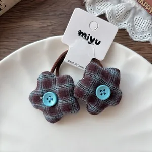 Détail de chouchous étoiles à carreaux bleus avec bouton sur une assiette en céramique