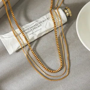 Détail d'un collier multicouche minimaliste en acier inoxydable doré, vue rapprochée